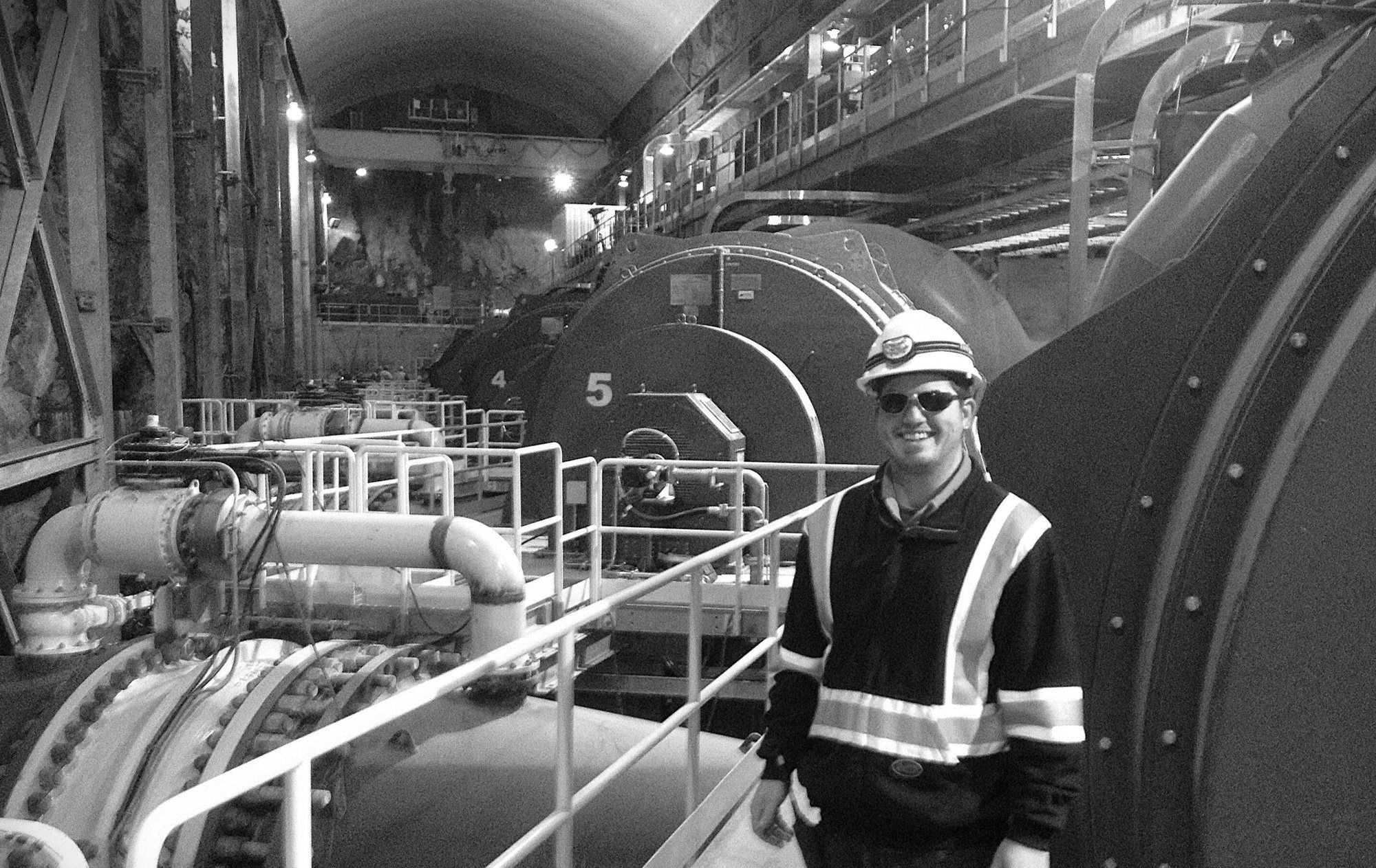 Jeff Burkinshaw in a hard hat beside generating equipment in a powerhouse